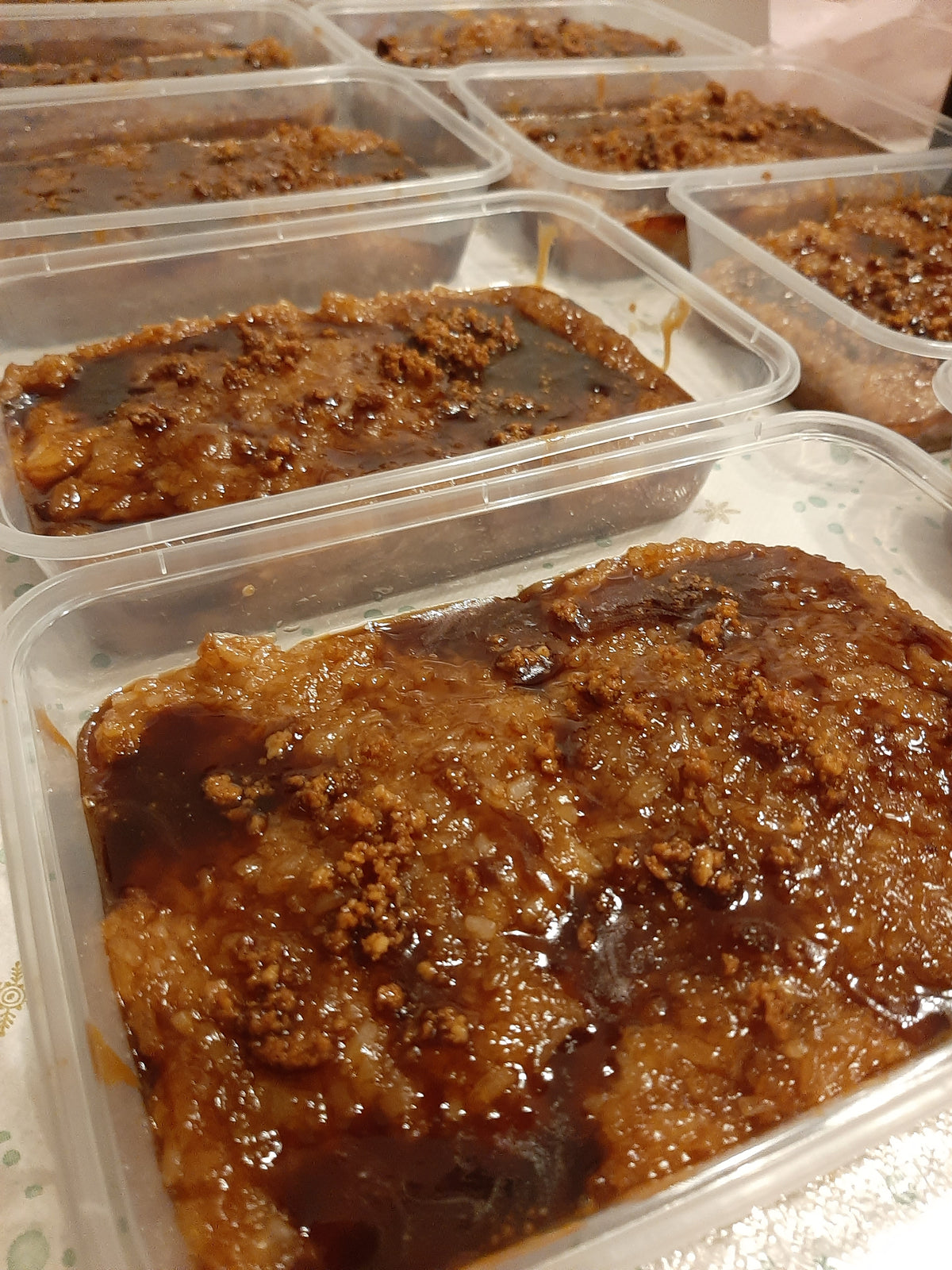 Rows of biko bibingka malagkit tubs with caramel coconut topping