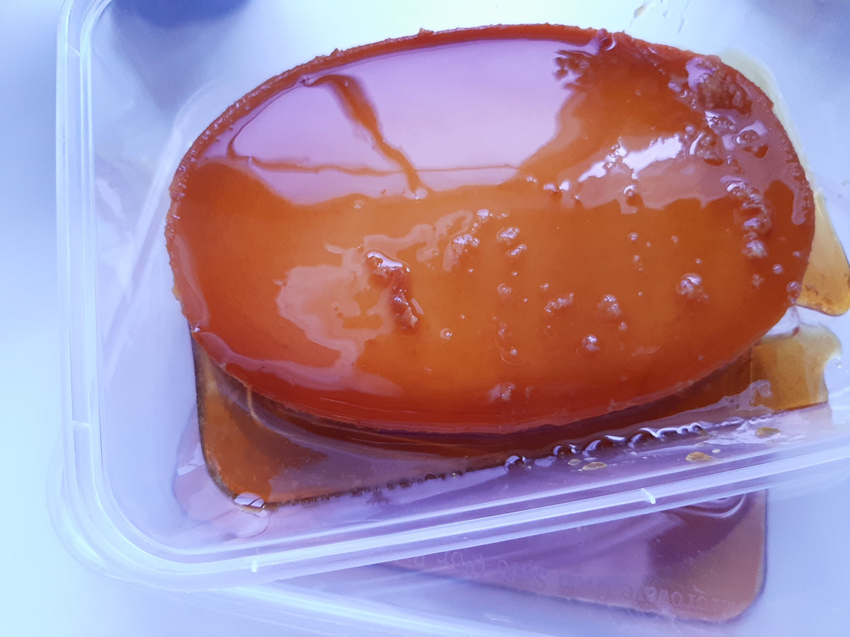 Overhead close-up of a whole caramel-coated leche flan