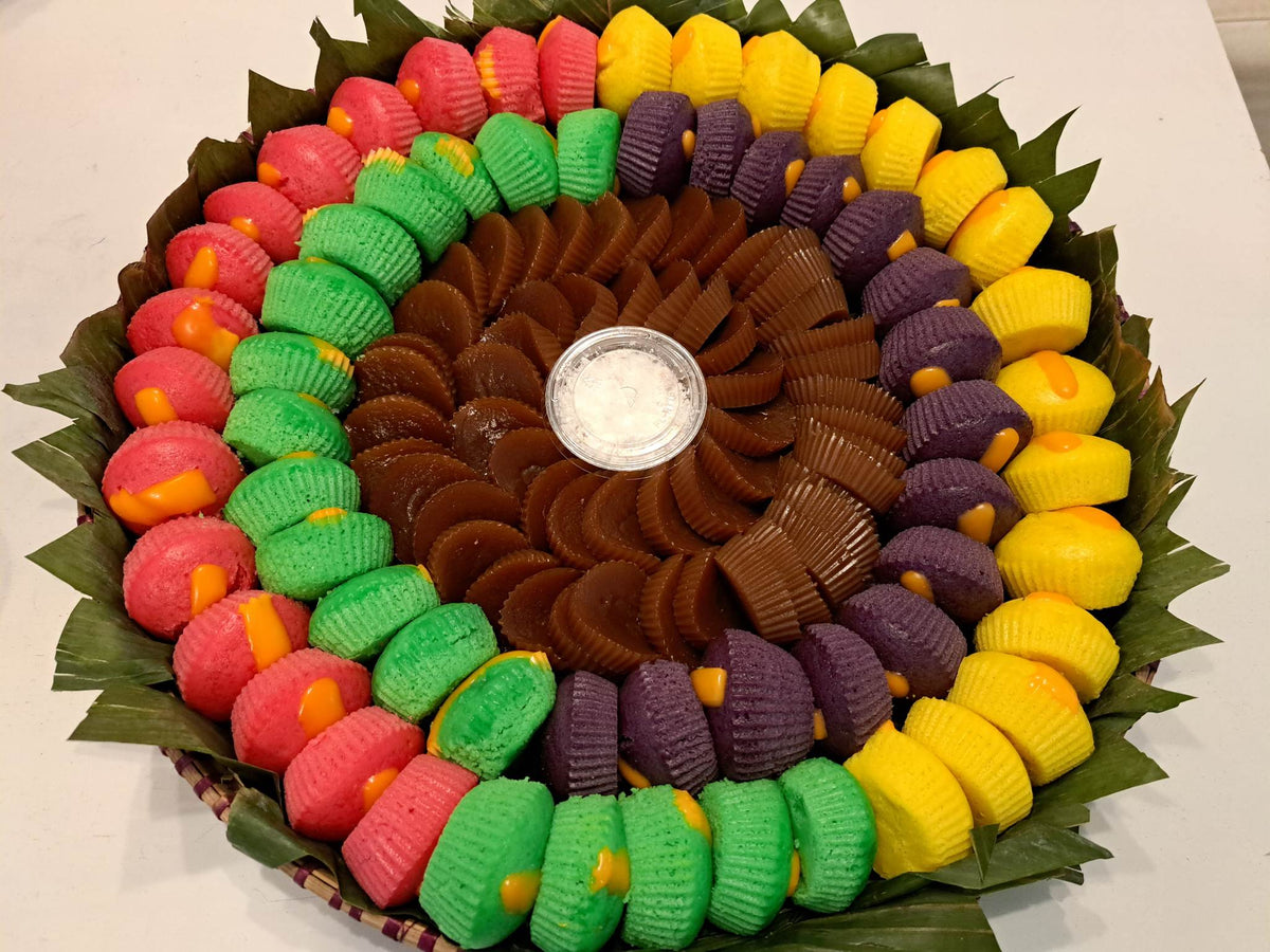 Colourful Filipino kakanin assortment arranged in a traditional bilao