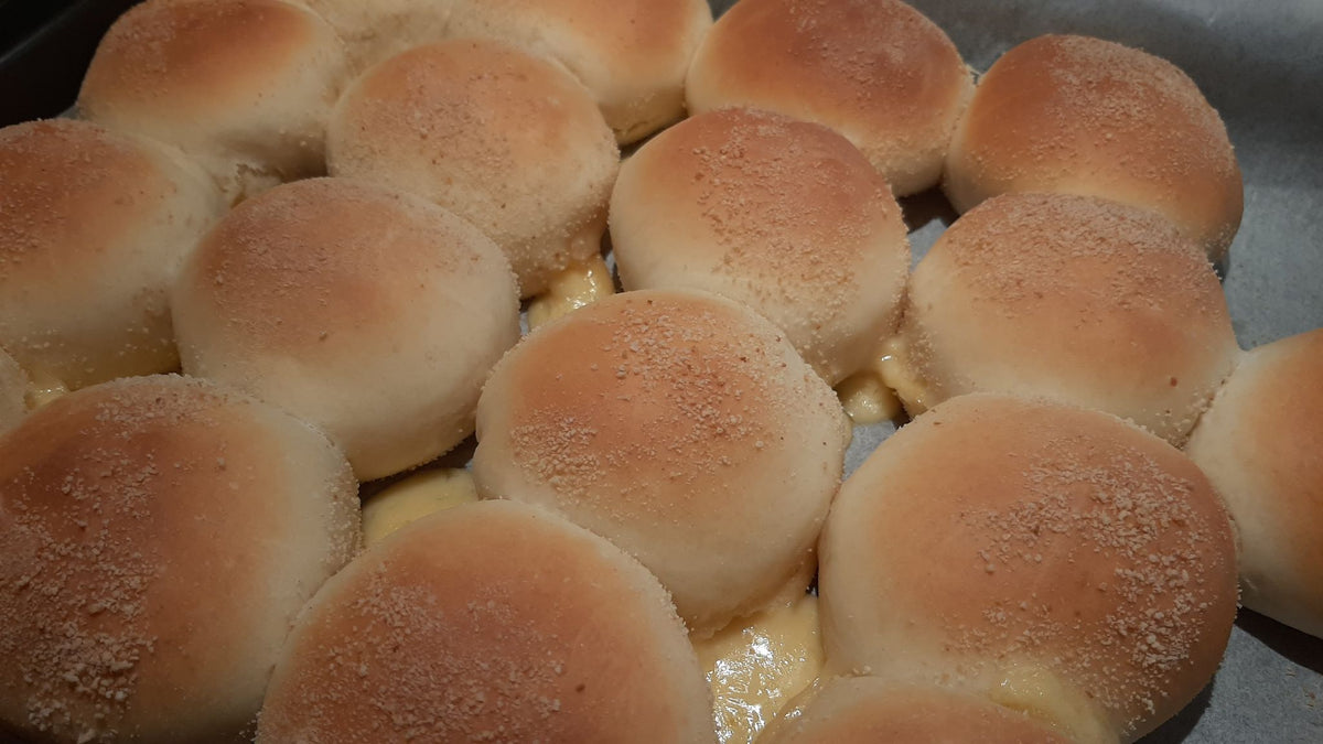 Close-up batch of soft cheese pandesal fresh from the oven