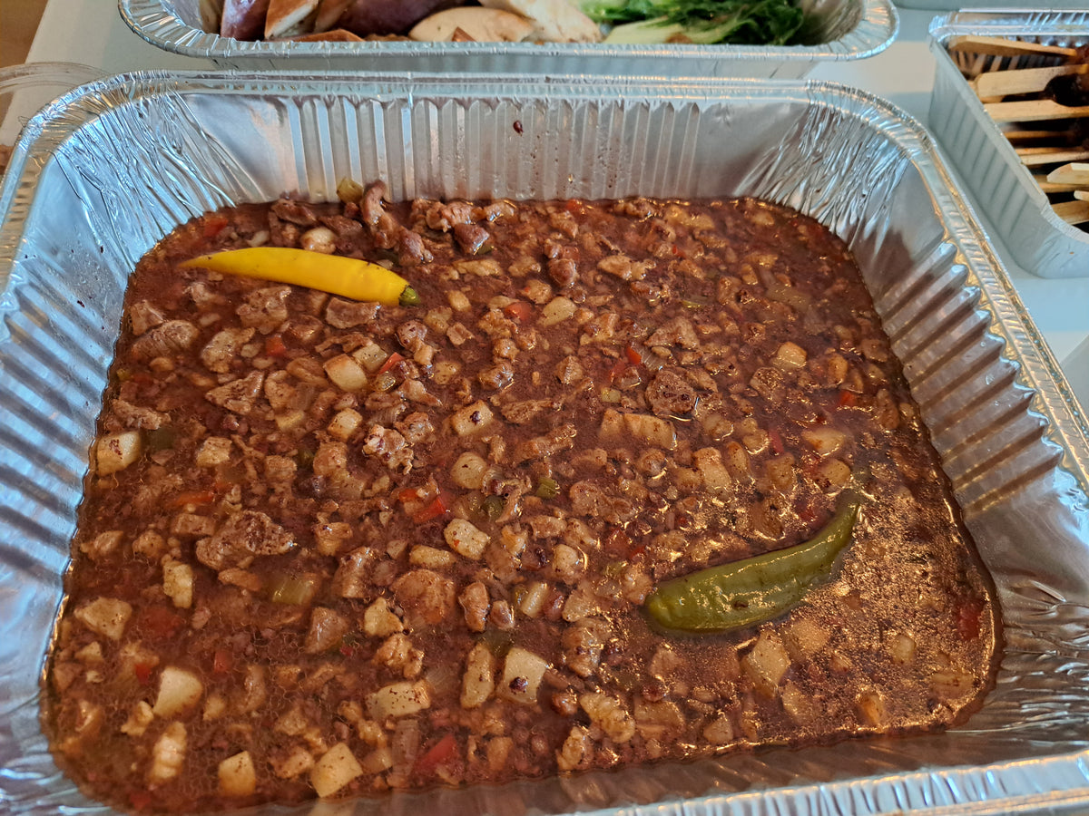 Tray of Filipino dinuguan pork blood stew with whole chillies