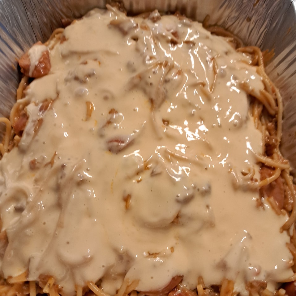Close-up of creamy cheese-topped sweet-style Filipino spaghetti