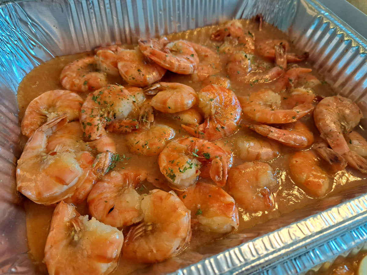 Close-up of garlic buttered shrimp with herbs in a catering tray