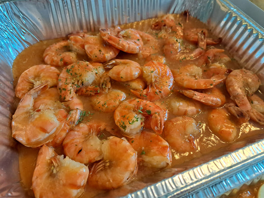Close-up of garlic buttered shrimp with herbs in a catering tray