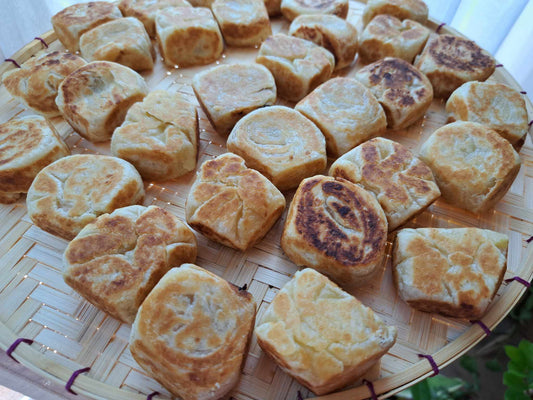 Homemade ube hopia pastries arranged on a woven serving tray