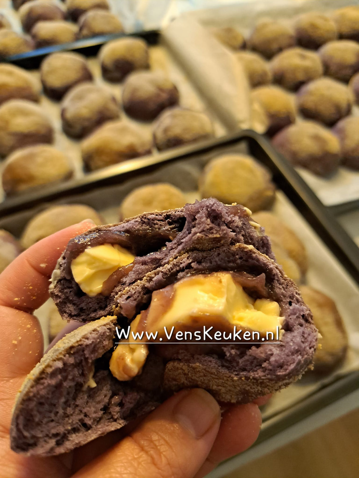 Coloured ube cheese pandesal opened to reveal cheese cubes
