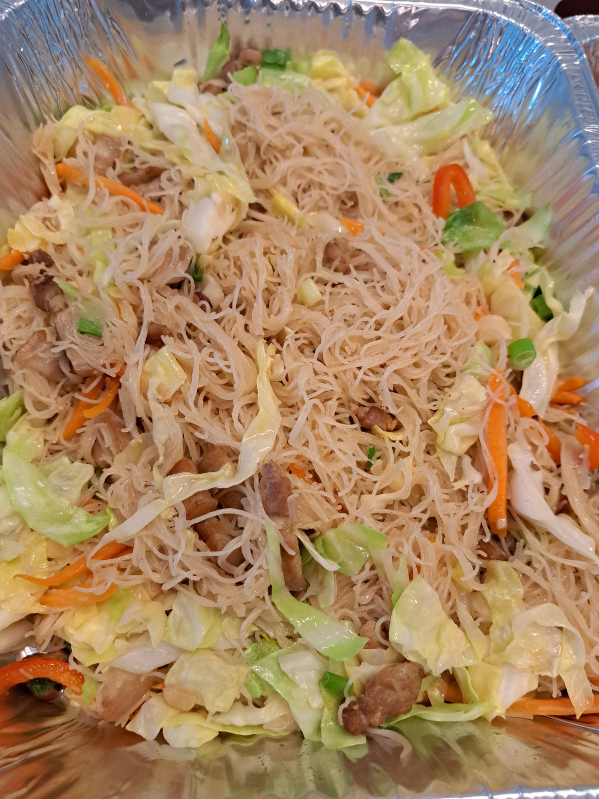 Close-up of pancit bihon noodles with shredded chicken and vegetables