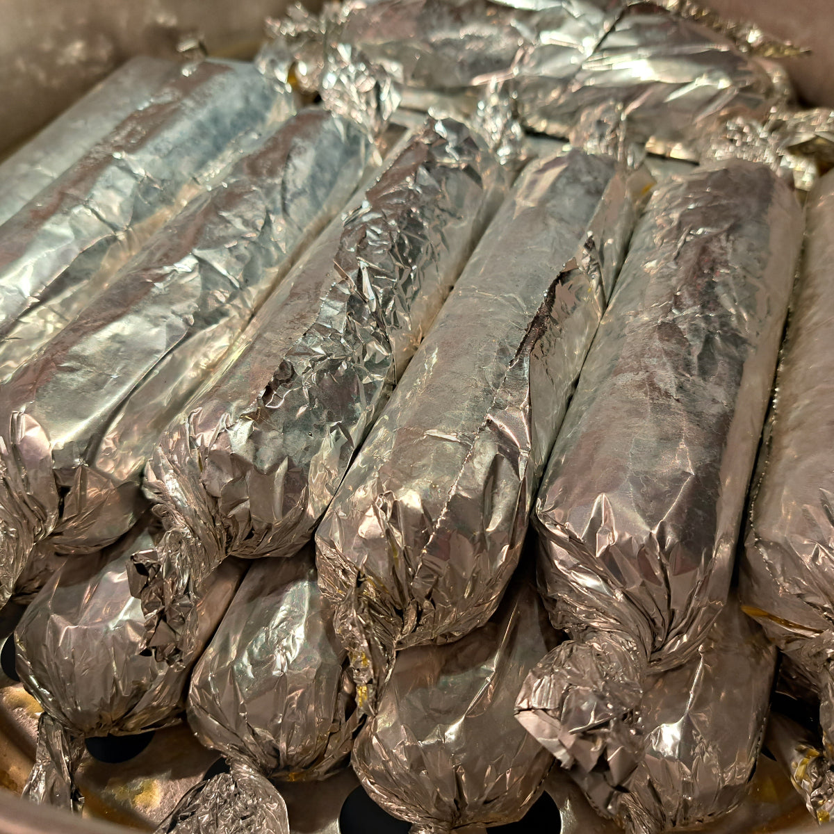 Homemade Filipino embutido rolls individually wrapped in aluminium foil