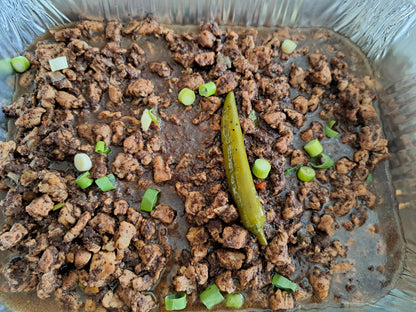 Filipino dinuguan garnished with spring onions and green chilli