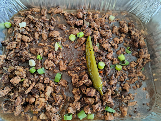 Filipino dinuguan garnished with spring onions and green chilli