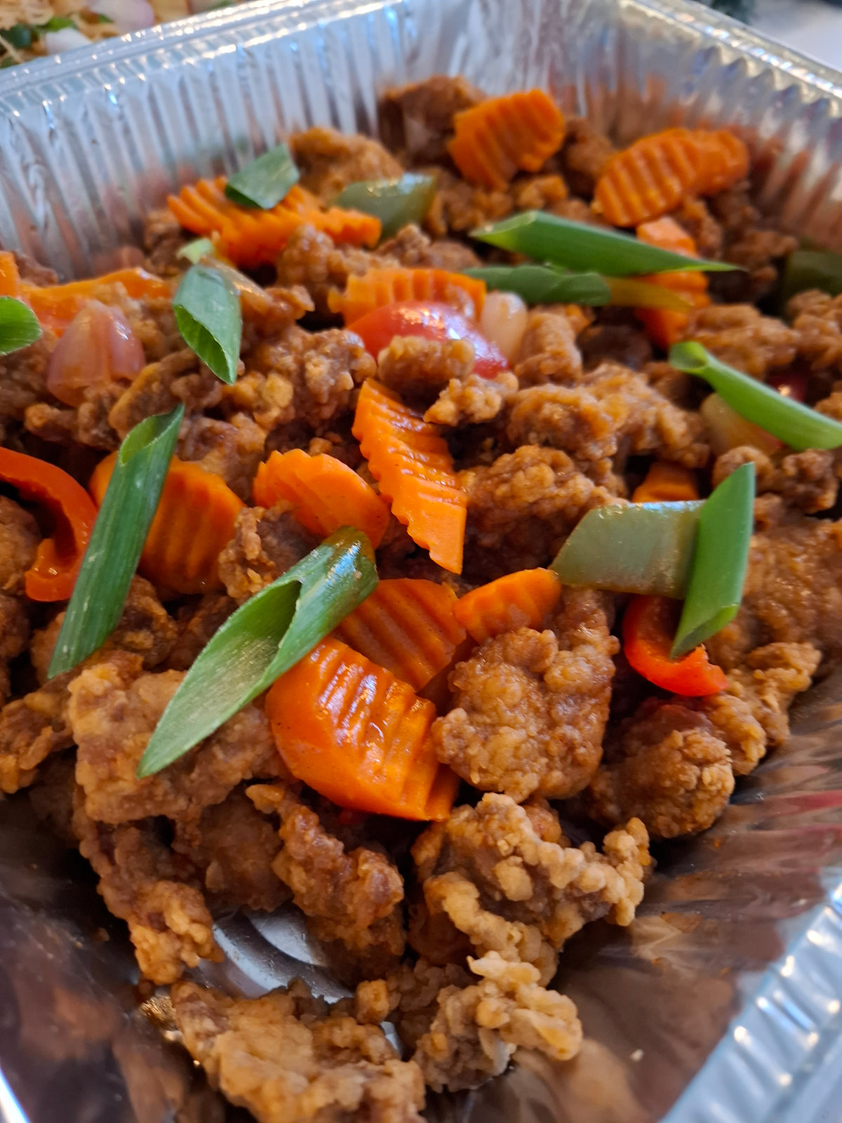 Close-up of sweet and sour chicken with carrots and peppers