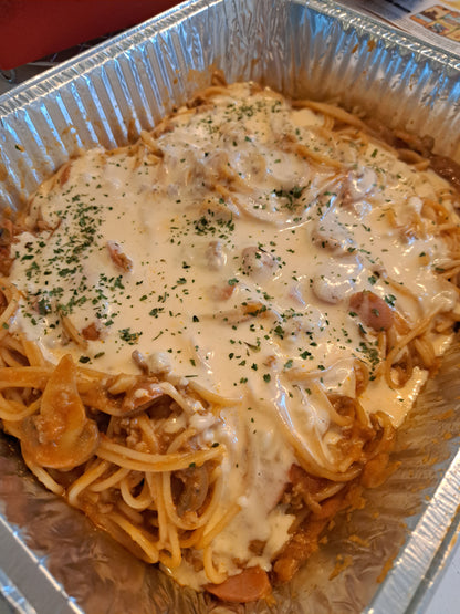 Angled view of sweet-style spaghetti covered with creamy melted cheese