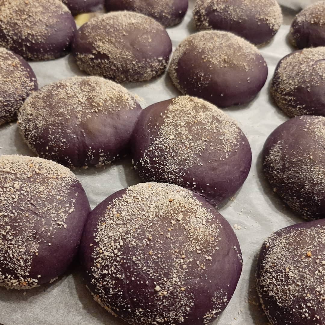 Close-up of freshly baked ube pandesal dusted with fine breadcrumbs