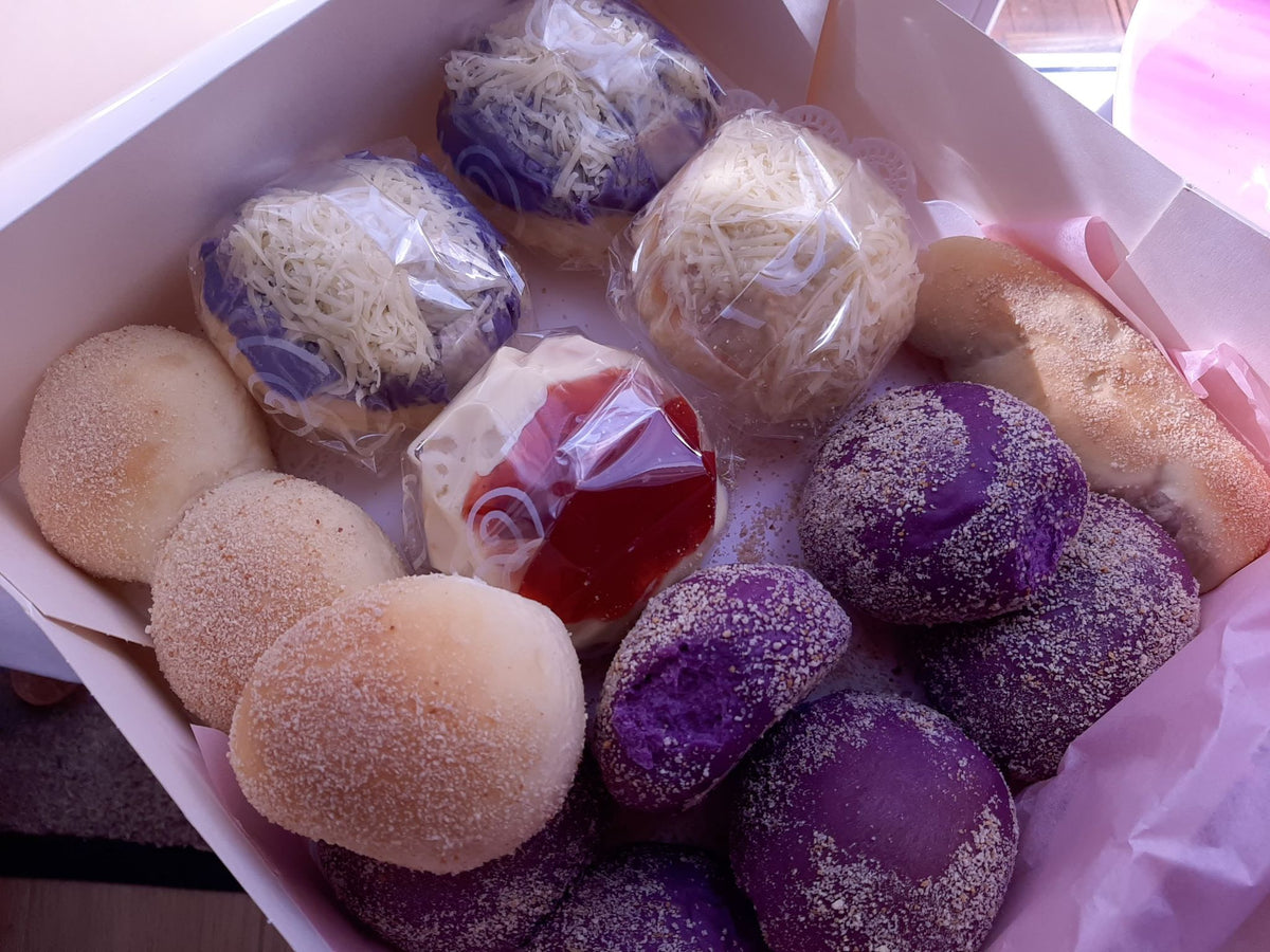Close-up of purple ube breads and individually wrapped ensaymada in a box