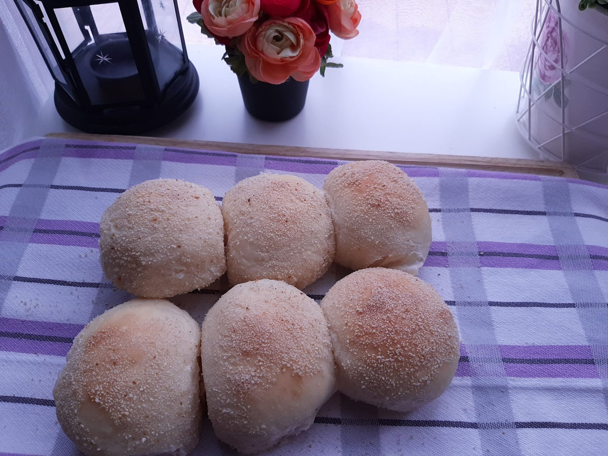 Six cheese pandesal rolls arranged on a checked cloth