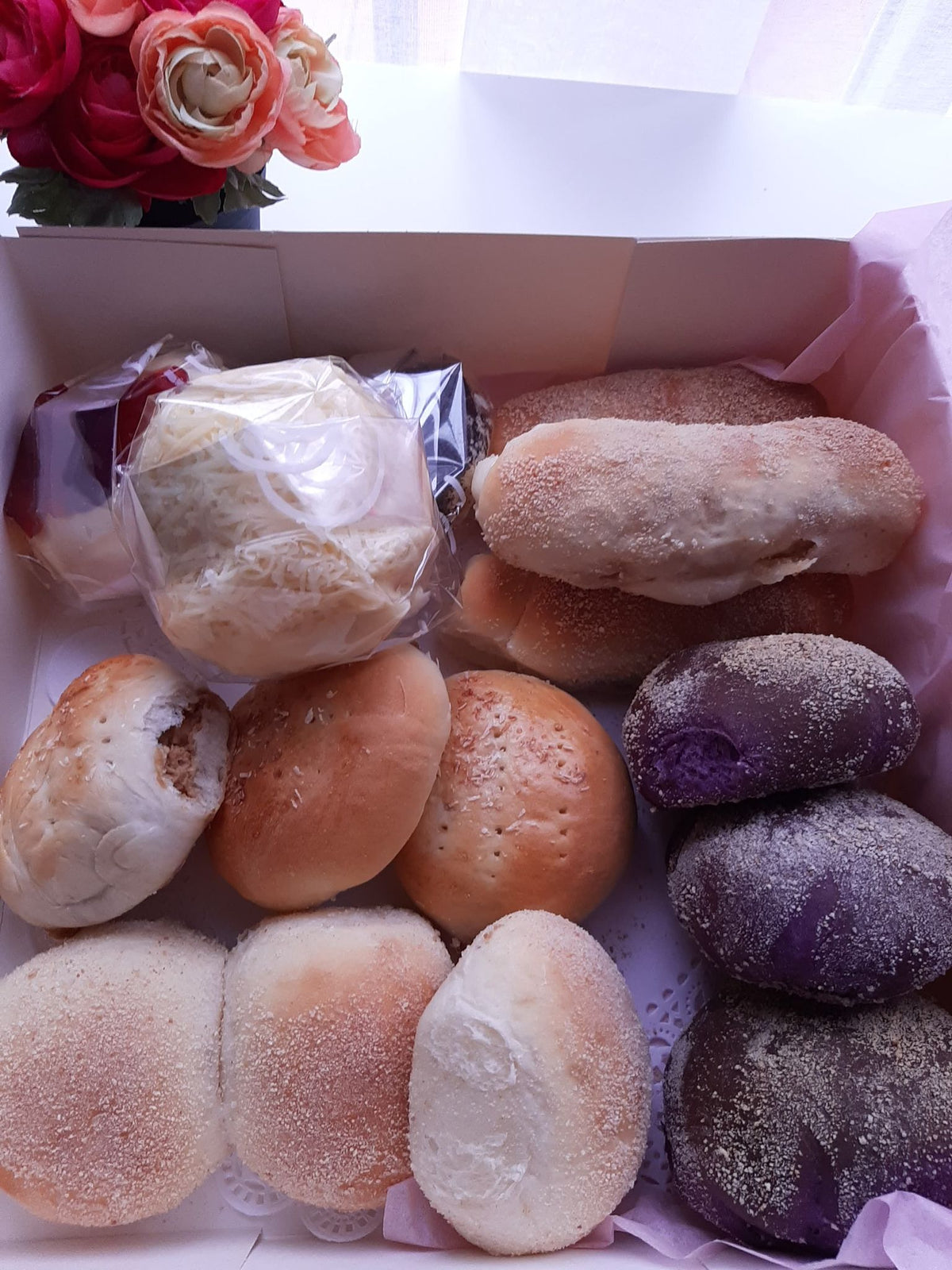 Open bread box filled with colourful assorted Filipino breads