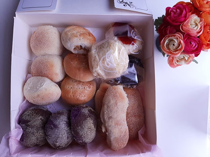 Assorted Filipino bread box with plain, ube and filled rolls