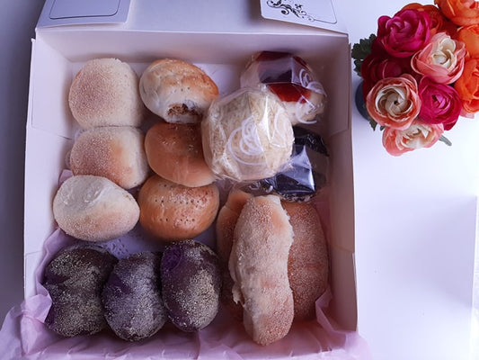Assorted Filipino bread box with plain, ube and filled rolls