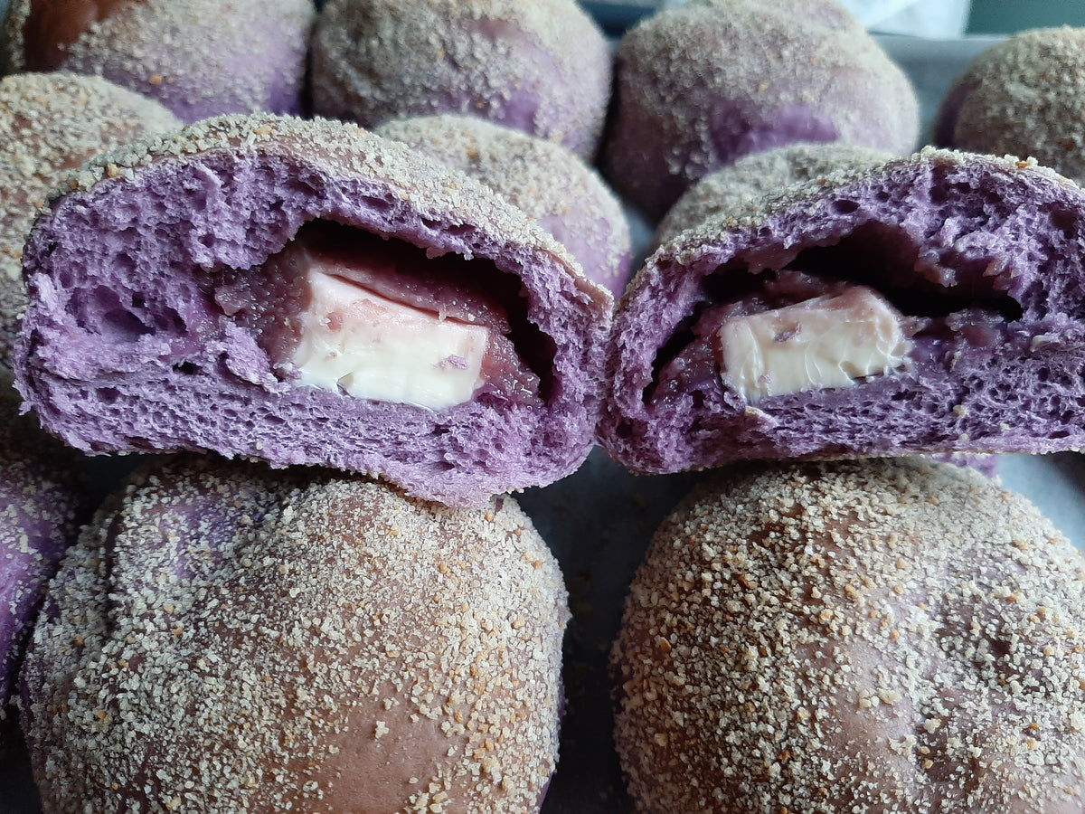 Two ube cheese pandesal halves showing the cheese centre