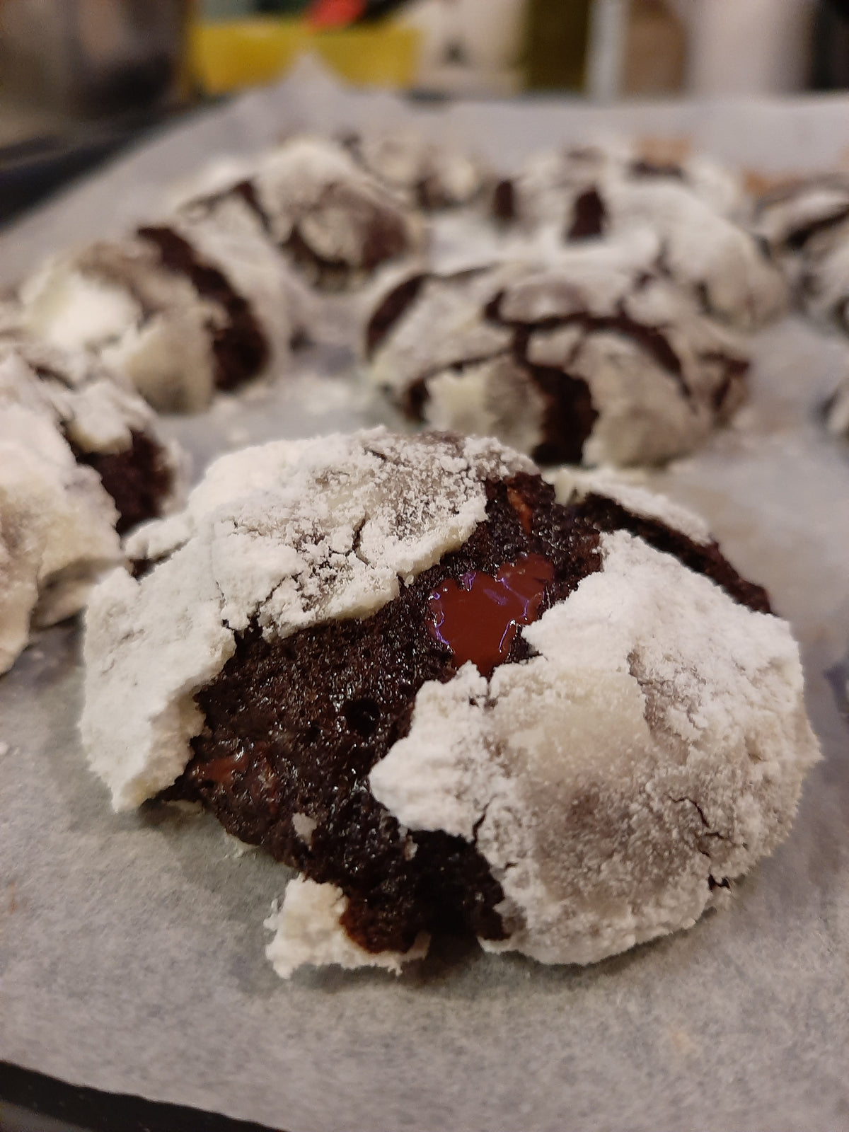 Chocolate crinkle cookie broken open to reveal a red centre