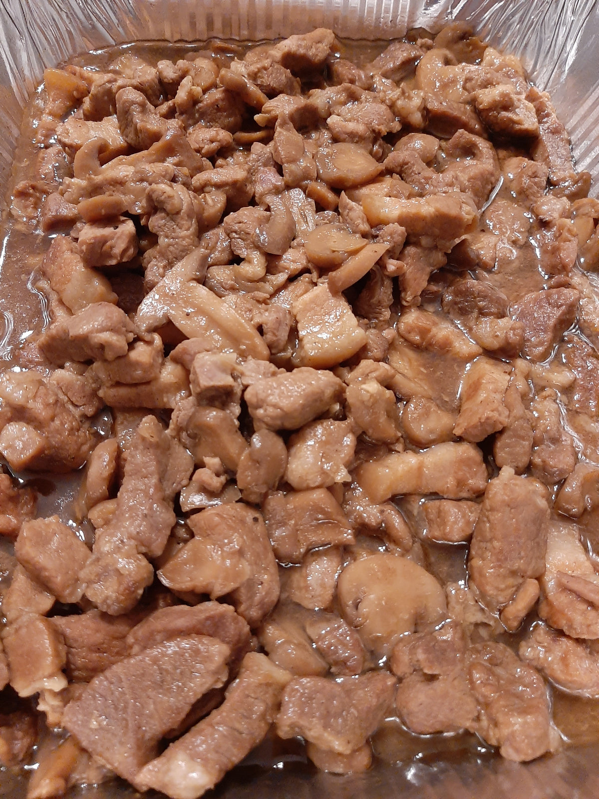 Pork asado pieces served in a foil catering tray