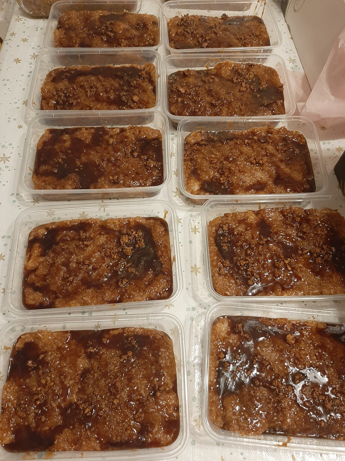 Freshly prepared biko bibingka malagkit portioned into clear takeaway tubs
