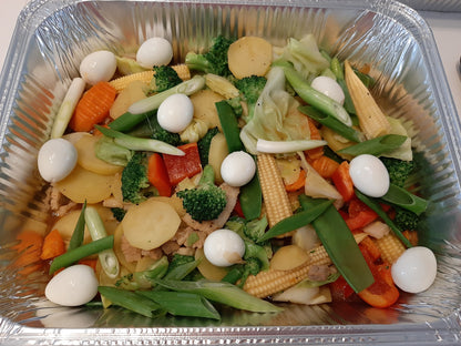 Filipino Chop Suey with mixed vegetables and quail eggs in a catering tray