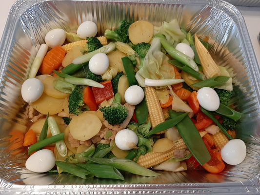 Filipino Chop Suey with mixed vegetables and quail eggs in a catering tray
