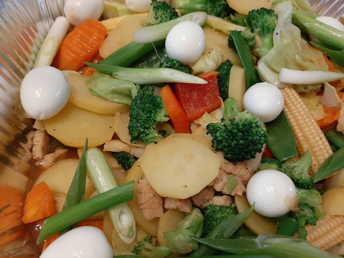 Close-up of Chop Suey with broccoli, carrots, baby corn and quail eggs