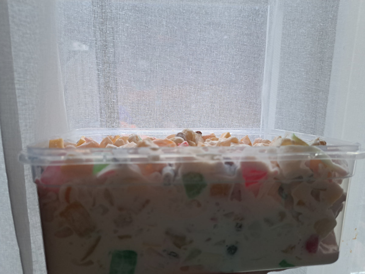 Side view of Filipino fruit salad in a large clear serving tub