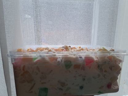 Side view of Filipino fruit salad in a large clear serving tub