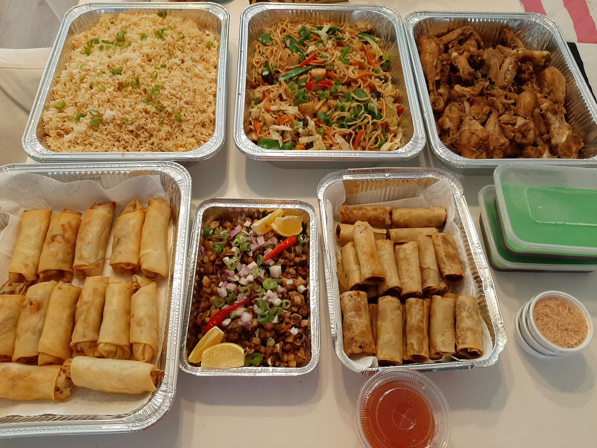 Filipino party spread featuring pancit Canton Guisado and lumpia