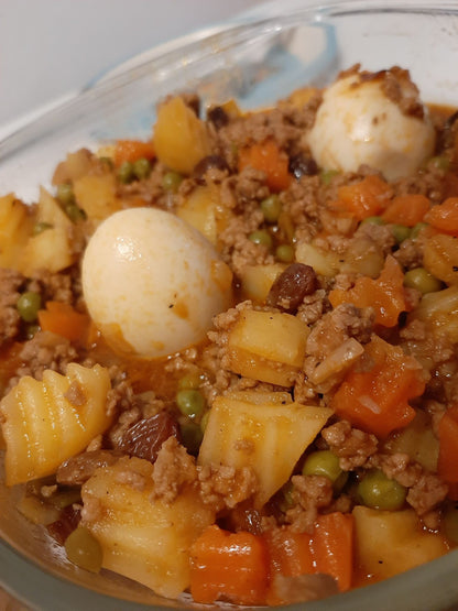 Close-up of pork giniling with potatoes, carrots, peas, raisins and boiled eggs