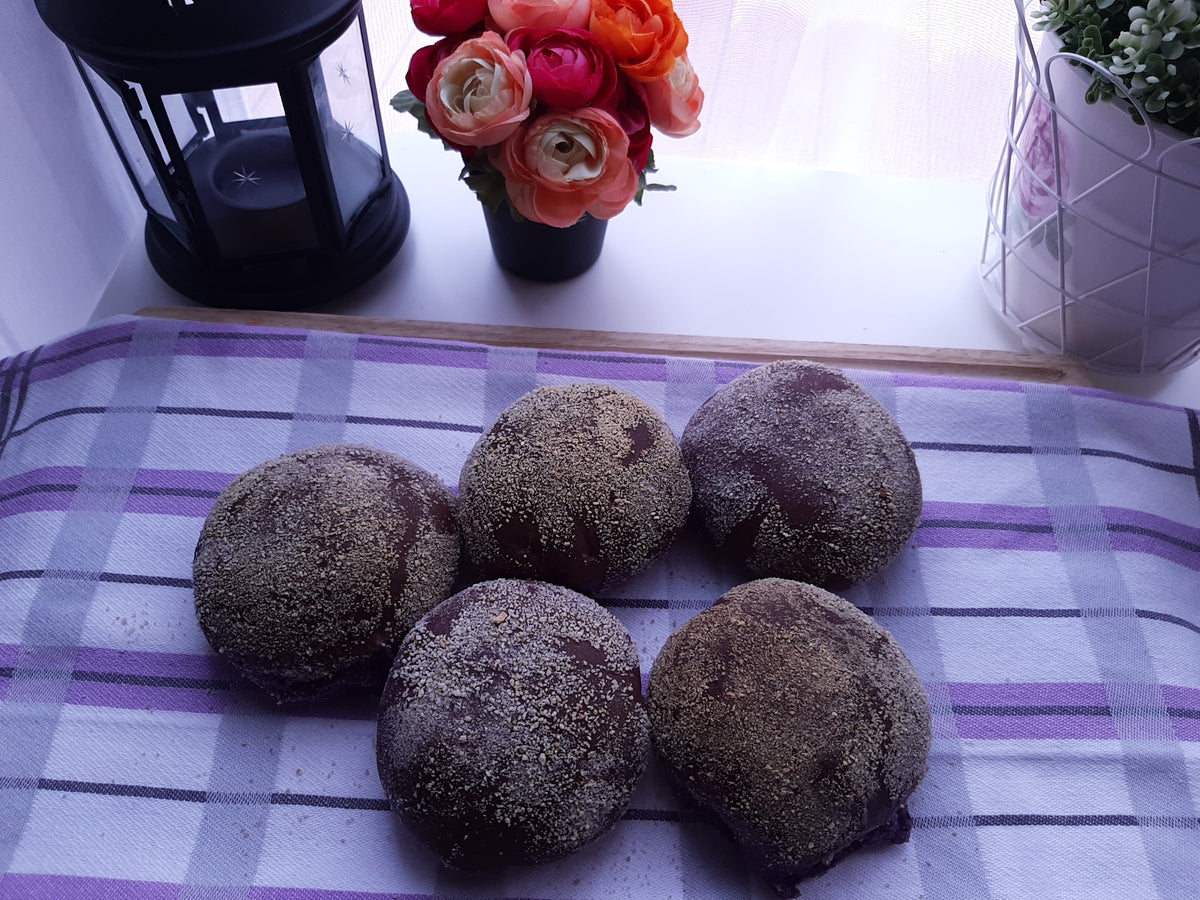 Five purple ube cheese pandesal rolls on a checked cloth