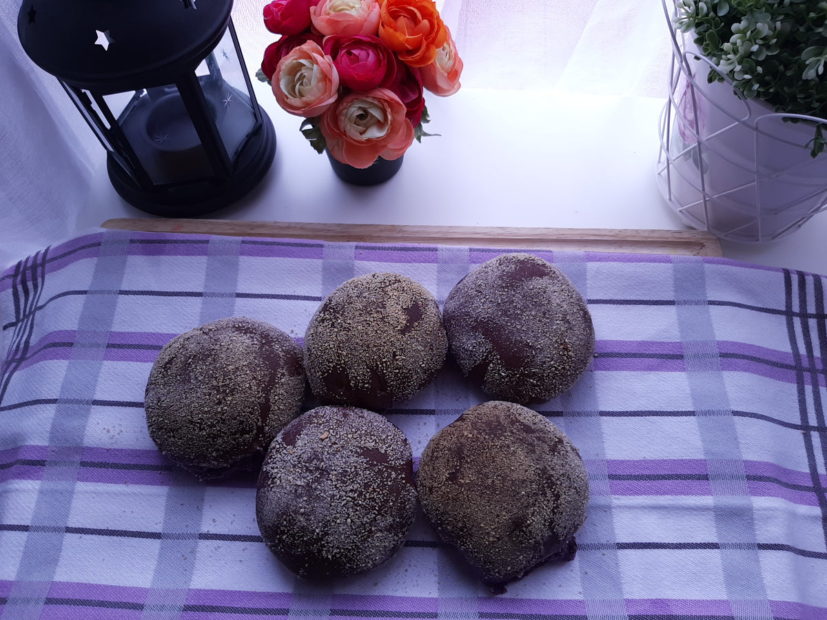 Six purple ube pandesal rolls arranged on a checked cloth