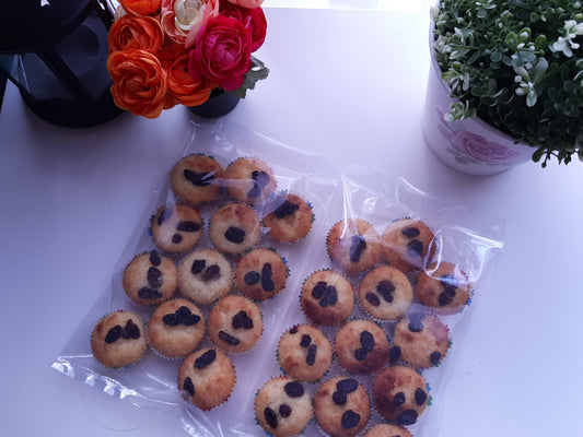 Mini coconut macaroons packed in clear bags beside fresh flowers