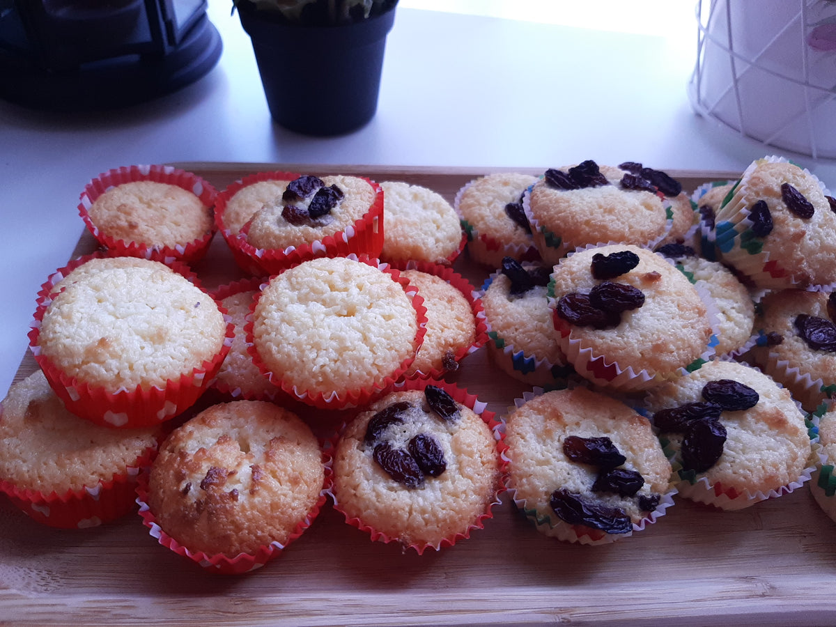 Assorted coconut macaroons in paper cases on a wooden board