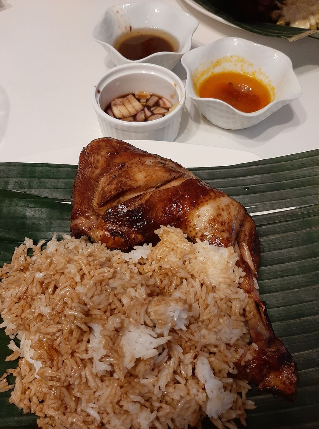 Baked thigh inasal served with garlic rice and Filipino dipping sauces