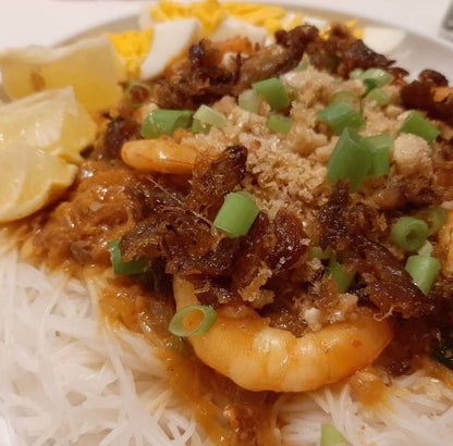 Close-up serving of pancit palabok with shrimp and savoury toppings