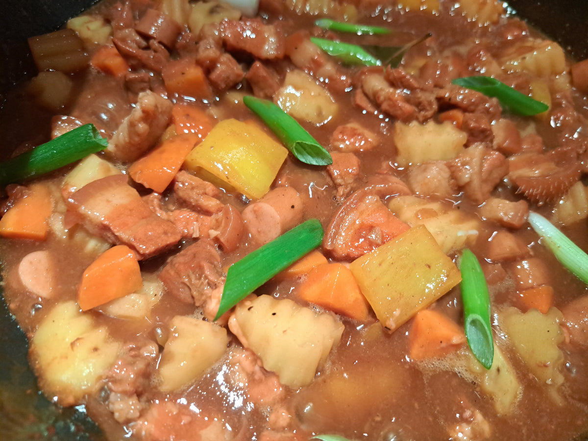 Close-up of pork menudo stew garnished with spring onions