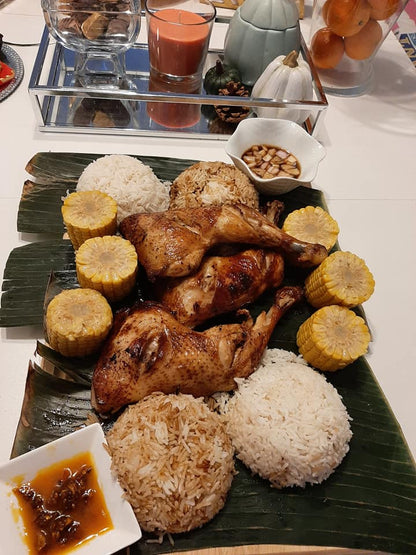 Large Filipino inasal sharing platter with chicken, rice and corn