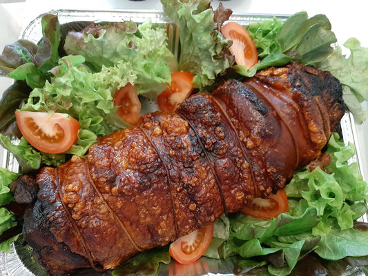 Two-kilo lechon belly roll with crisp crackling on lettuce and tomato