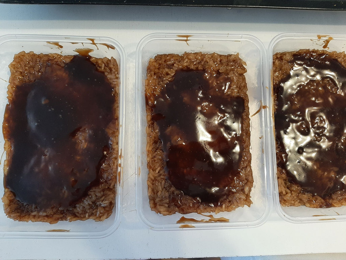 Three tubs of biko bibingka malagkit topped with dark caramel coconut sauce