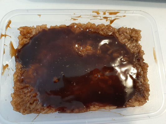 Biko bibingka malagkit with glossy caramel coconut topping in a clear container