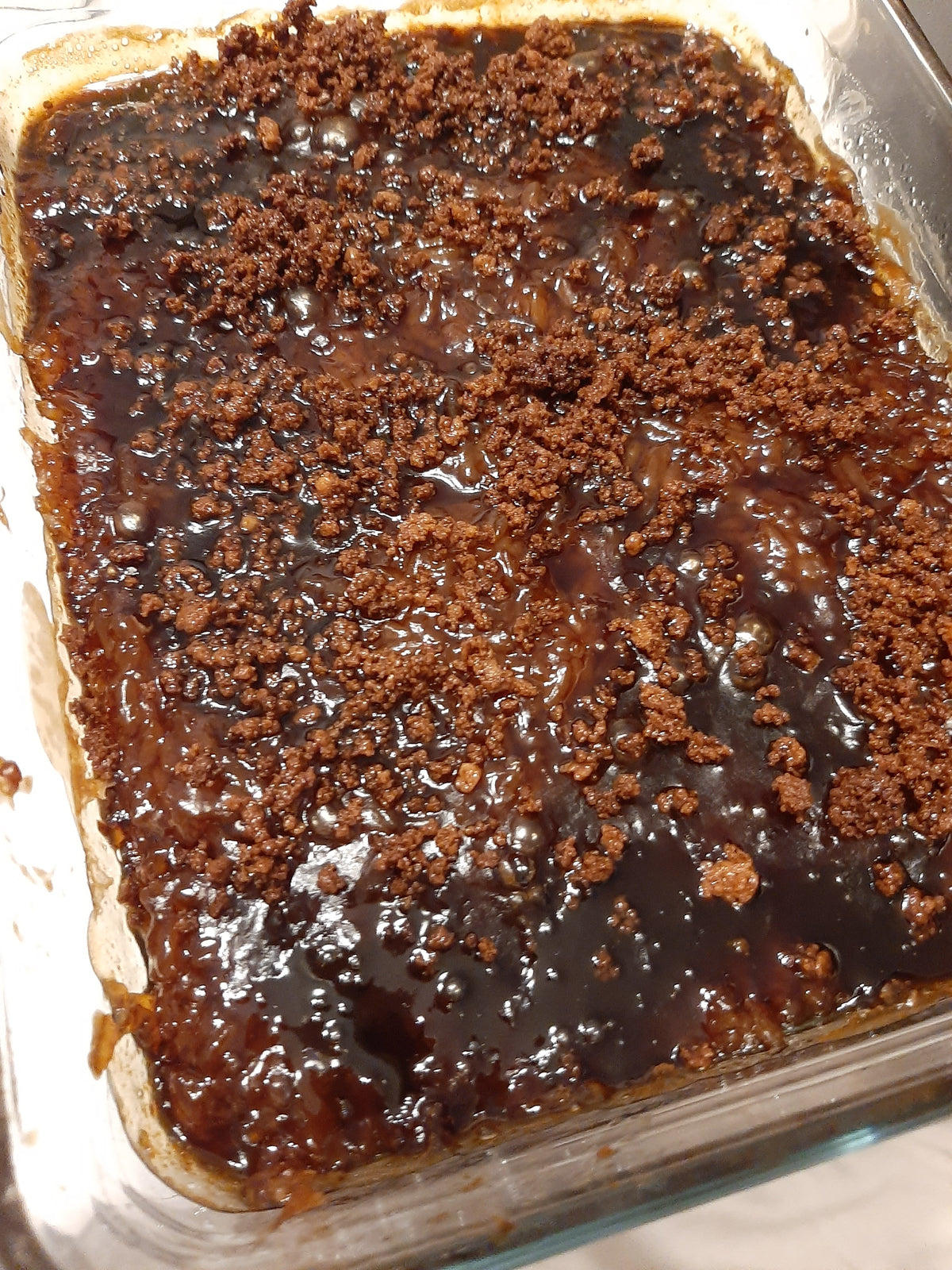 Large glass tray of biko bibingka malagkit with toasted coconut topping