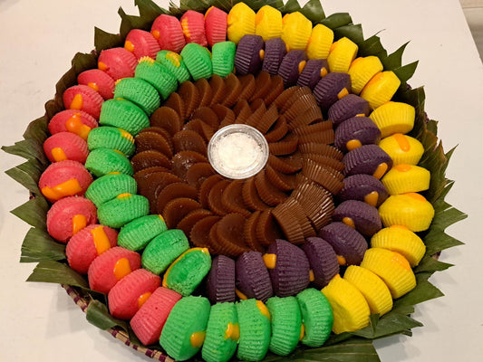 Colourful Filipino kakanin assortment arranged in a traditional bilao
