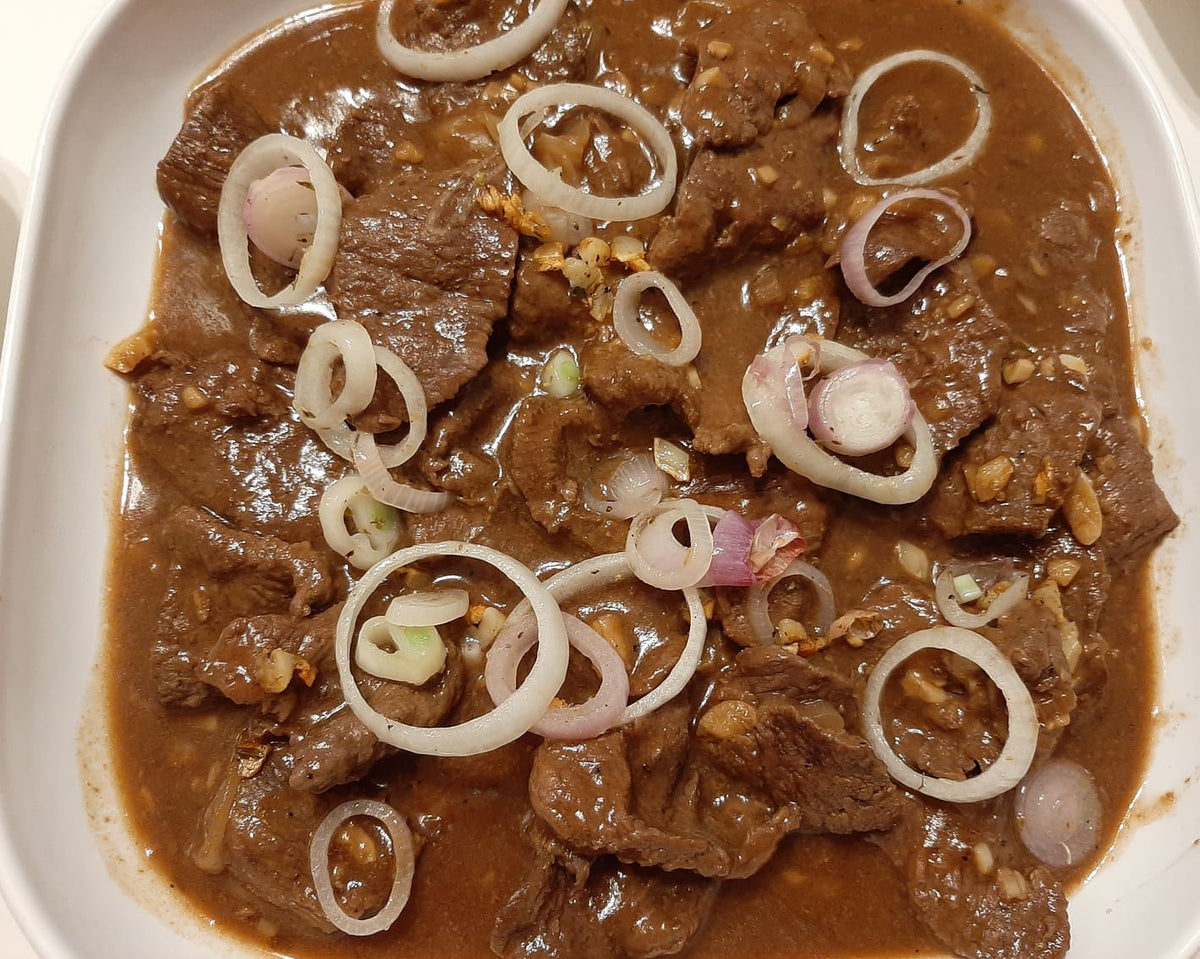 Plated Bistek Tagalog with beef slices and onion rings
