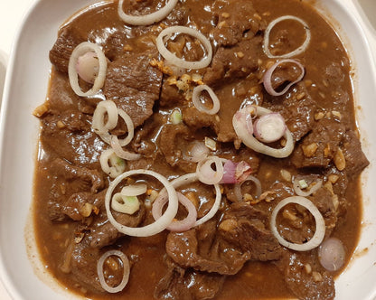 Plated Bistek Tagalog with beef slices and onion rings