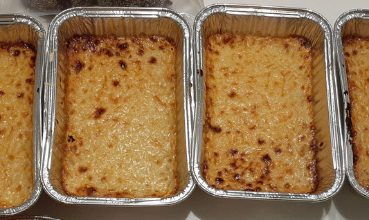 Homemade Filipino cassava cakes with golden tops in individual foil tubs