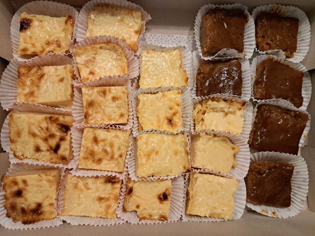 Assorted cassava cake squares with golden and caramelised tops in a box